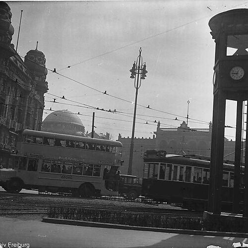 Historische Schwarz-Weiß-Aufnahme des belebten Potsdamer Platzes in Berlin mit Verkehrsturm, Straßenbahnen, Autos und zahlreichen Passanten im Jahr 1927.