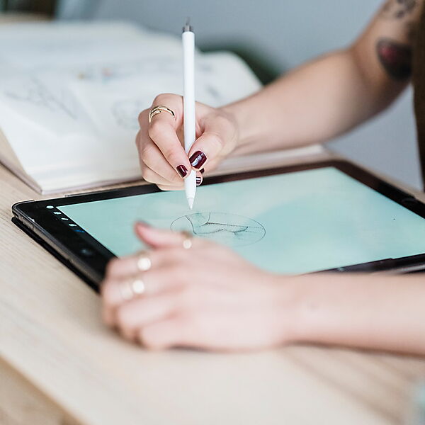 Frau arbeitet kreativ an einem digitalen Arbeitsplatz und verbindet Gestaltung mit moderner Zeichentechnik.