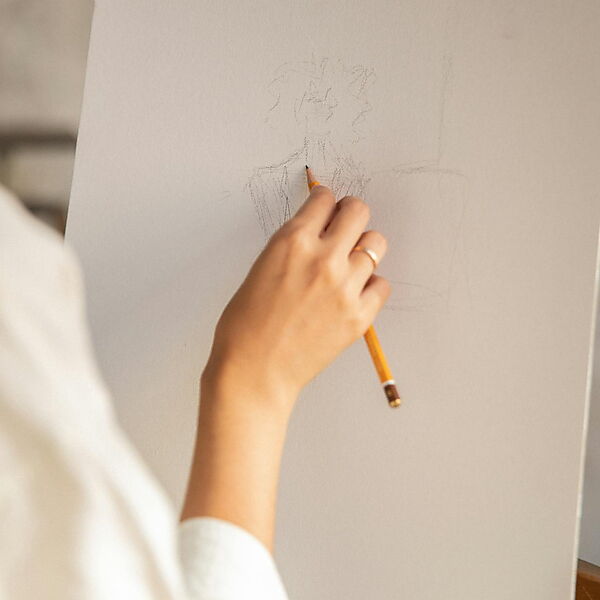 Hand zeichnet mit einem Bleistift auf Papier und zeigt den entspannten Einstieg ins Zeichnenlernen.