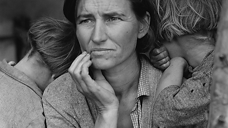 Schwarz-Weiß-Fotografie von Florence Owens Thompson mit einem Baby im Arm und zwei Kindern, die sich an ihre Schultern lehnen.