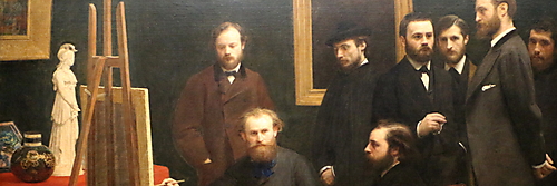 Acht dunkel gekleidete Männer versammeln sich in einem Atelier um Édouard Manet, der mit Palette und Pinsel vor einer Staffelei sitzt.