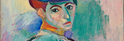 Eine sitzende Frau mit großem farbigem Hut blickt aus dem Halbprofil nach vorn; ihr Gesicht ist in Grün, Gelb, Rosa und Violett gemalt.