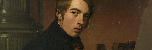Johann Friedrich Overbeck sitzt mit einer geöffneten Bibel vor einer hellen, noch unbemalten Leinwand; Bücher, eine Büste und Zeichenstifte umgeben ihn.